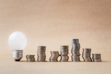 Multiple stacks of coins next to a light bulb