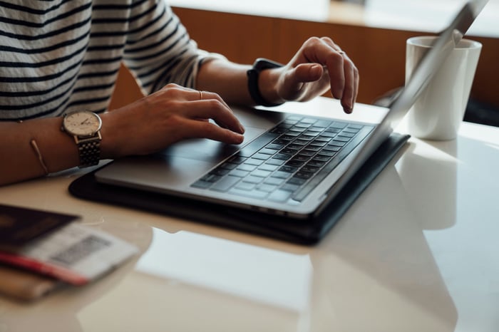 Person typing on a laptop at a table.