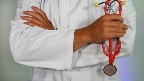 Doctor holding his arms crossed with a stethoscope in his right hand. 